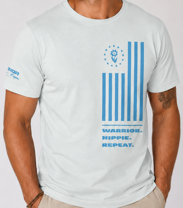 A man wearing a white crewneck t-shirt with a blue graphic print on the front featuring a lion emblem and the text 'WARRIOR. HIPPIE.